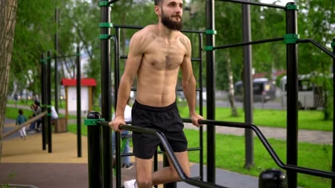 A man of Arab appearance without a T -shirt at pulling bars does exercises. Stock Footage 199421966