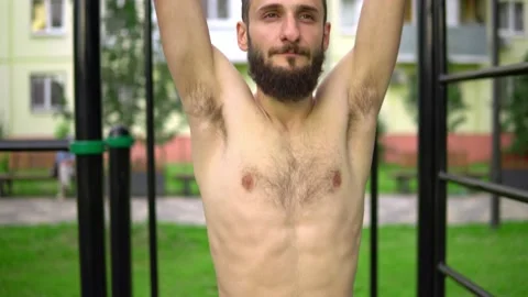 A man of Arab appearance without a T -shirt at pulling bars does exercises. Stock Footage 199422151