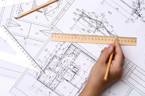 Man architect draws a plan, schedule, design, geometric shapes with a pencil and Stock Photos