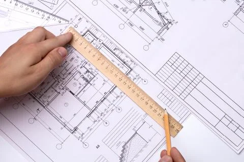 Man architect draws a plan, schedule, design, geometric shapes with a pencil and Stock Photos