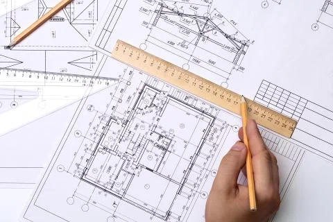 Man architect draws a plan, schedule, design, geometric shapes with a pencil and Foto stock