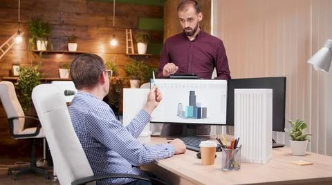 Man architect explaining building construction structure to his engineer Stock Photos