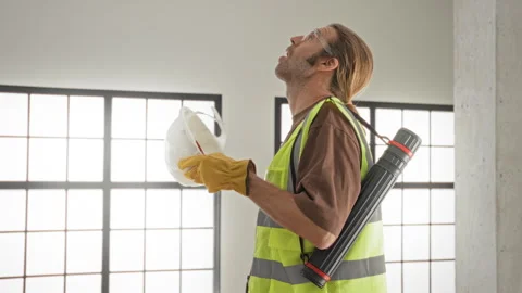 Man architect holding hardhat and pointing upward with gloved hand in build.. Video stock 337376047