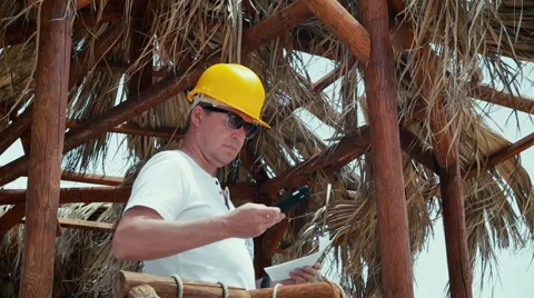 Man architect or engineer in a helmet studies blueprints outdoor 스톡 동영상 64478947