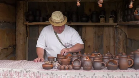 Man arranges clay pots on a table Stock Footage 82409115