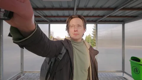 A man arrives at the bus stop and checks the schedule to see when his bus is Video stock 333010343