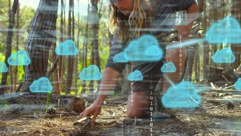 Man arriving with sticks, preparing tinder to ignite while blue tech overlay Stock Footage 333234211