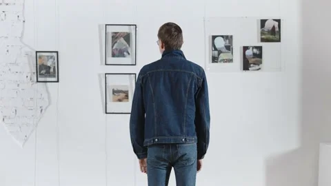 A man in an art gallery, view from the back. Exhibition of abstract paintings in Stock Footage 224817937