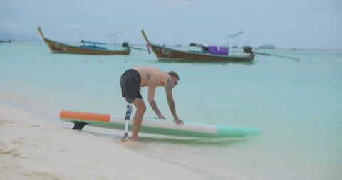 Man with artificial leg walking to ocean water for paddle surfing in slow motion 库存影片 201367039