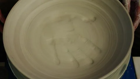 Man artisan in pottery workshop making clay pot on rotary machine Stock Footage 242386164