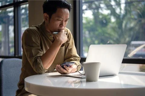 Man asian working laptop computer and smartphone on desk focused on his wor.. Foto stock