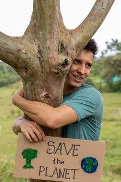 Man asks save the planet. Young adult latin man holds sign asking to save the Stock Photos