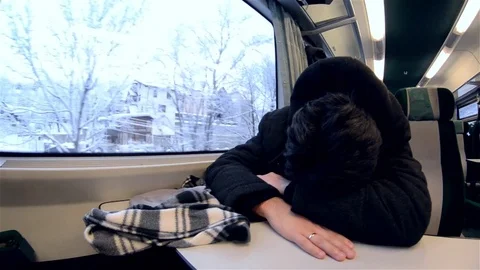 Man asleep with his head on the table while the train takes him home Stock Footage 78218688