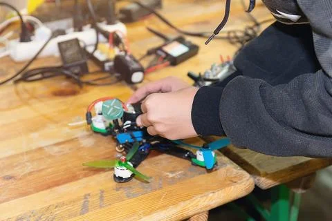A man assembles and configures a high-speed drone. FPV drone Stock Photos