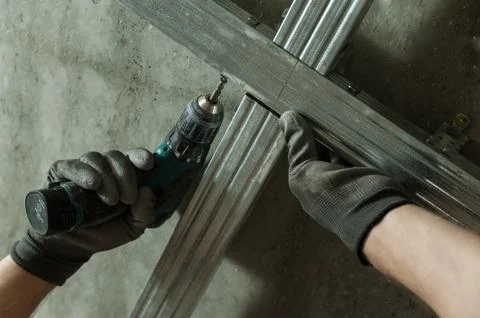 Man assembles profile metal frame Stock Photos