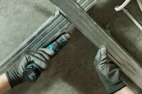 Man assembles profile metal frame Stock Photos
