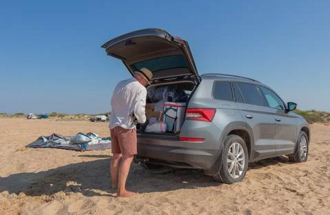 A man assembles a tent on the seashore. Stock Photos