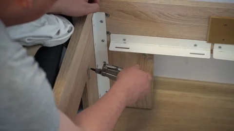 Man Assembling Bed, Screwing Bolt into Bed Frame, DIY Furniture Assembly Stock-Footage 316706424
