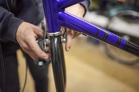 Man assembling the brake system of a bicycle as part of the maintenance servi Stock Photos