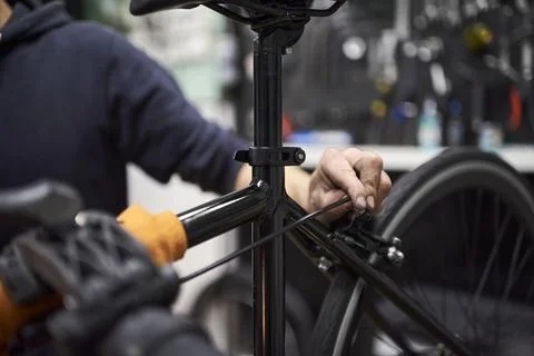 Man assembling the braking and shifting system of a bicycle at his workshop Foto stock