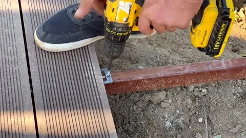 Man assembling composite deck using cordless screwdriver Stock Footage 166173801