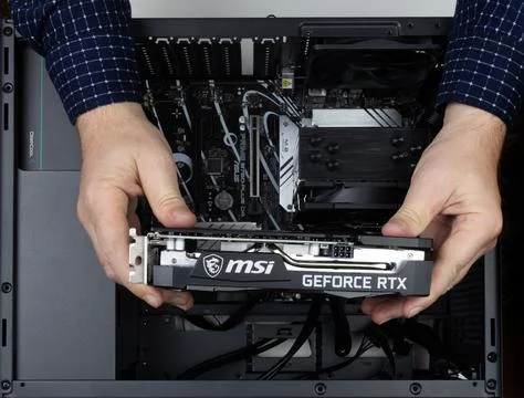 Man assembling computer, holding new msi geforce rtx graphics card Stock Photos