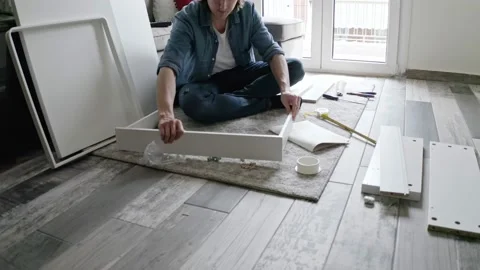 Man assembling DIY furniture in the living room. Stock Footage