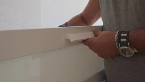 Man assembling drawer handle on white furniture Vidéo 341443560