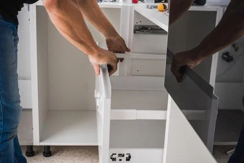 Man assembling the drawers of a kitchen unit Stock Photos
