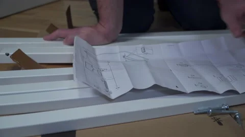 Man assembling flat pack furniture DIY at home on floor. Man bought furniture Stock Footage 150770191