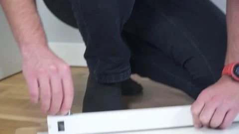 Man assembling flat pack furniture DIY at home on floor. Man bought furniture Stock Footage 150771211