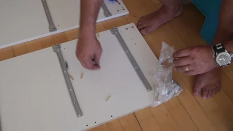 Man assembling flat pack furniture at home Stock Footage 341443637