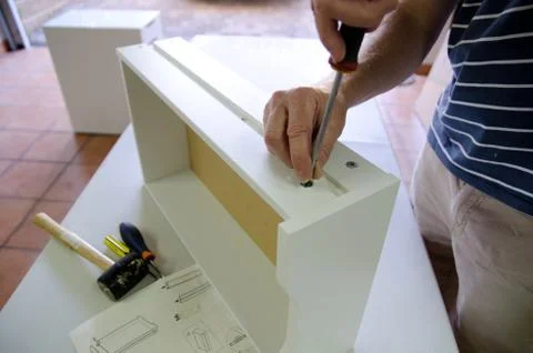 Man assembling flatpack drawer unit Foto stock