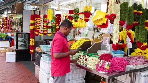 Man Assembling Flower Garlands at Little India Market Stall Vidéo 314491005