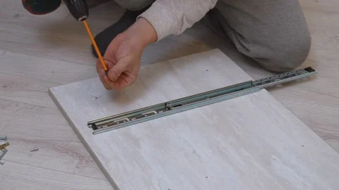 Man assembling furniture and installing drawer slides Stock Footage 326145993