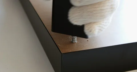 Man assembling a furniture, screwing a table leg Stock Footage 105696553