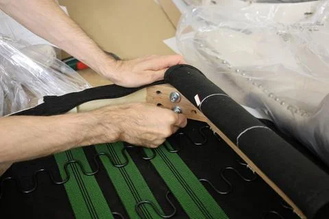 Man assembling furniture using power drill, installing bolts into frame at home 写真素材