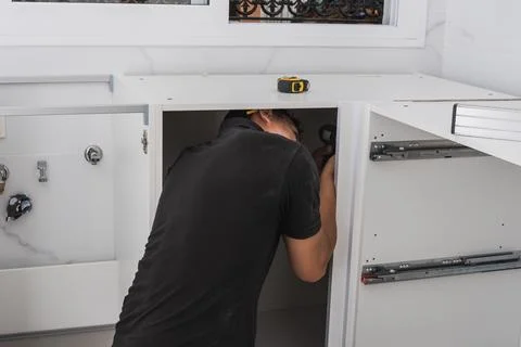 Man assembling a kitchen cabinet Stock Photos