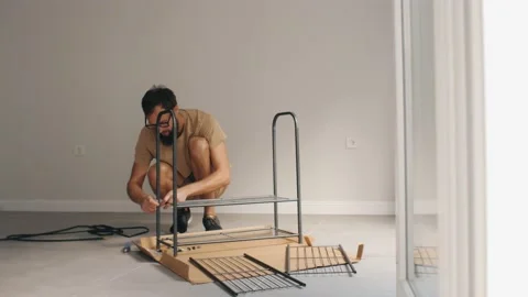 Man assembling metal shelf home decor create comfortable customizing Stock Footage 233470219