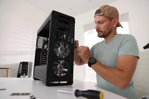 Man assembling new computer at white table Stock Photos