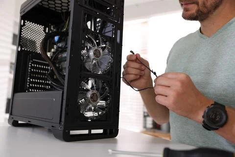Man assembling new computer at white table, closeup Stock Photos