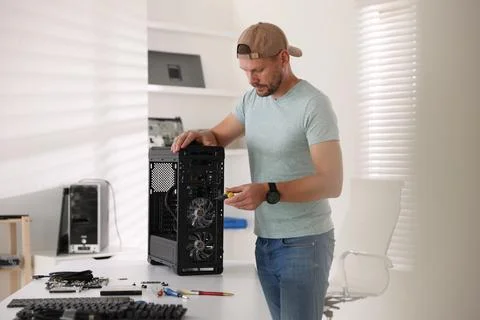 Man assembling new computer at white table Stock Photos