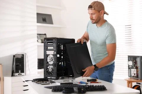 Man assembling new computer at white table Stock Photos