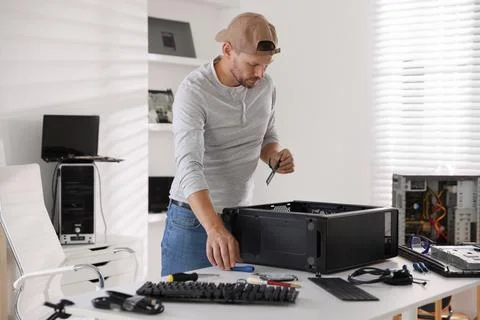 Man assembling new computer at white table Stockfoto's