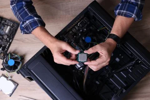 Man assembling new computer at wooden table, top view Stock-Fotos