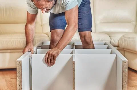 Man assembling a shelving at home 写真素材