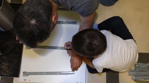 A man assembling white furniture Video stock 116725313