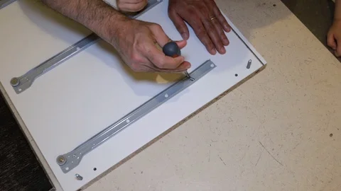 A man assembling white furniture Video stock 116725376