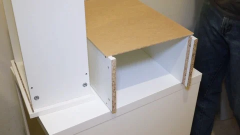A man assembling white furniture Video stock 116725489