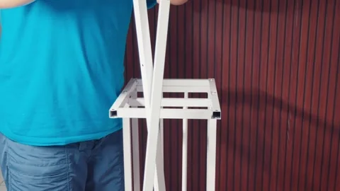 Man Assembling White Metal Frame, DIY Furniture Construction Stock Footage 333316764
